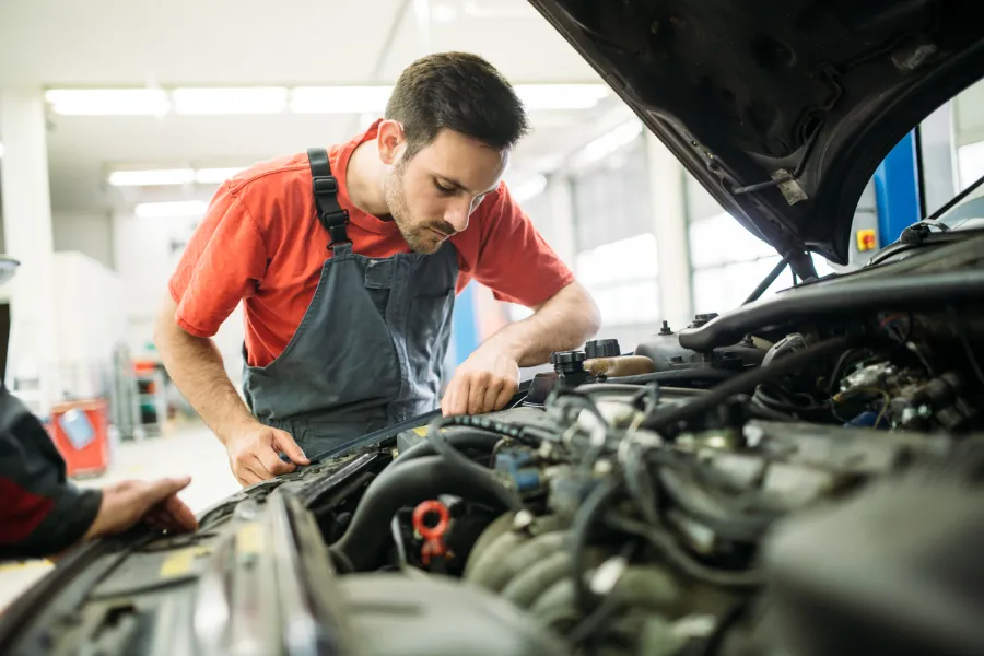 Mécanicien travaillant sur le moteur d'une voiture